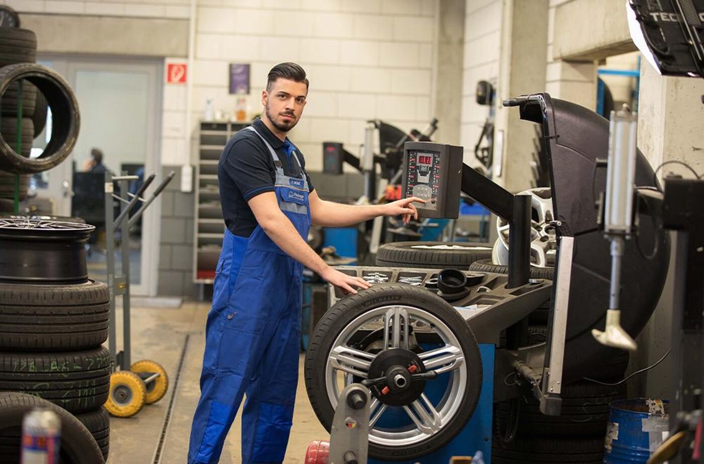 Pneuhage Mechaniker an der Wuchtmaschine